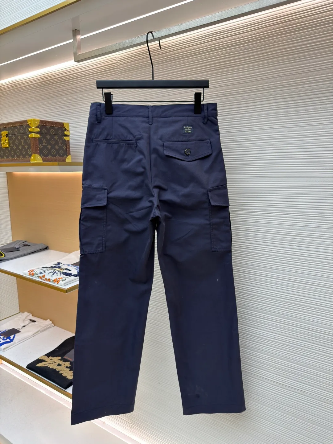 LOUIS VUITTON pocket embroidered work trousers ●Original version: Purchased and developed for 9999 ●Item number: 1681825-B50 ●Fabric: cotton twill fabric ●Technology: embroidery production ●Color: navy blue ●Version: fitted version ●Weight: about 520 grams ●Size: 44-46-48-50 ●Description: The high cotton content ensures the fabric's excellent breathability, durability and classic workwear texture, while the twill weave gives it unique wear resistance and stiffness. The special fabric technology solves the pain points of tight and stiff traditional overalls; it provides greater freedom when moving, significantly improves wearing comfort and flexibility, and achieves a balance between function and comfort. The application of three-dimensional core-spinning embroidery technology in the pocket position is achieved by adding additional cotton thread or foam as the core material to the pattern filling layer, and then using embroidery thread to fully cover the embroidery. The logo pattern is significantly protruded from the surface of the fabric, forming a full three-dimensional effect. This process not only enhances the visual impact and tactile level, but also improves the wear resistance of the pocket area through the buffering effect of the core material, ensuring that the pattern can still remain crisp and not deformed in complex daily use, ensuring that the pattern is clear and durable, and injecting a sense of sophistication into the rugged workwear style. Diversified pocket system combines workwear functionality with sophistication. The flap cargo pockets on both sides are a signature element, and their flap design prevents items from falling and enhances the visual three-dimensionality. Italian style pockets provide simple side storage. The overall wiring is straight and delicate, the fabric is comfortable and soft, and the color is consistent without color difference. It can be matched with the same style to create a fashionable look and control various occasions. Customized accessories, complete with three standards, same style for men and women!